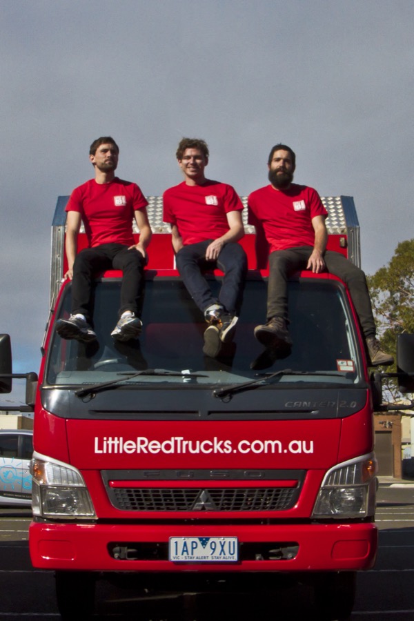 Three Little Red Trucks team members sitting on top of a Little Red Trucks removal truck